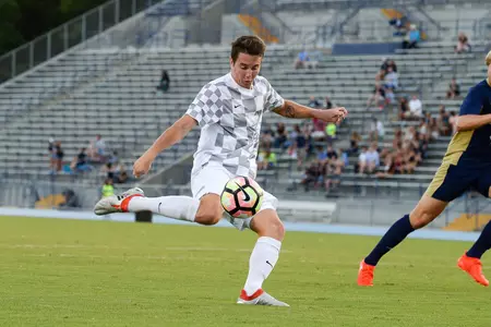 UNF men's soccer player strikes the ball