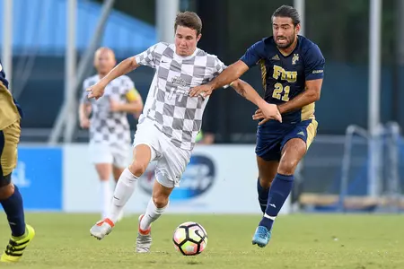 UNF men's soccer player fight for possession of the dribble