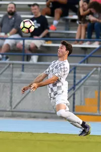 UNF men's soccer player chest the ball