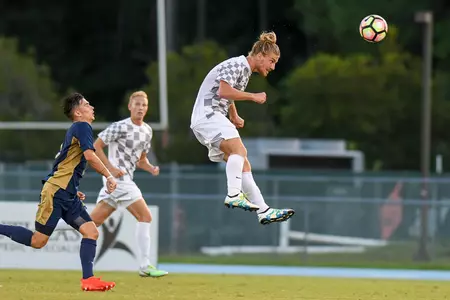UNF men's soccer player heads the ball in the air