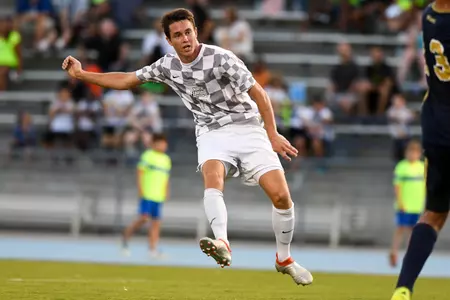 UNF men's soccer player passes the ball