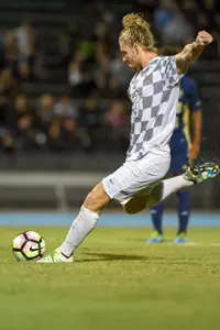 UNF men's soccer player kicks the ball