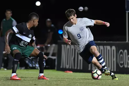 UNF men's soccer dribbles the ball past opponent