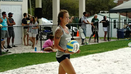 UNF beach volleyball player gets ready to serve the ball