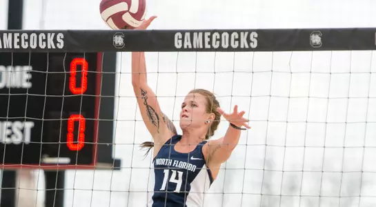 UNF beach volleyball player up at the net for a tip