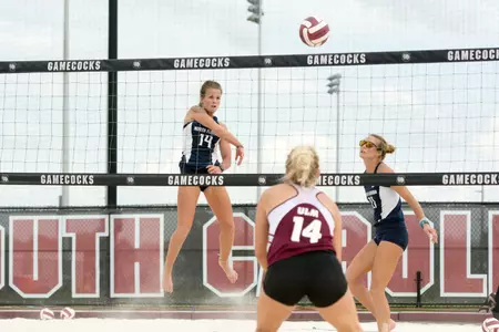 UNF beach volleyball player spikes the ball