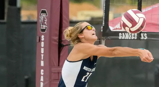 UNF beach volleyball player makes a bump pass to teammate