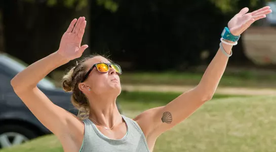 UNF beach volleyball player throws ball up for a serve