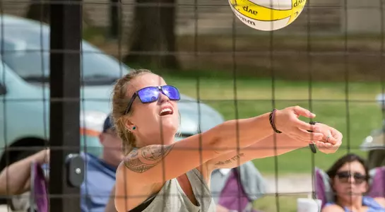 UNF beach volleyball player passes the ball
