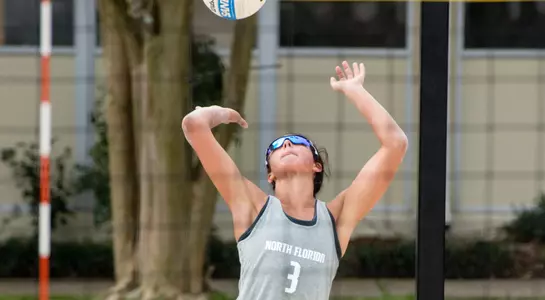 UNF volleyball player serves the ball