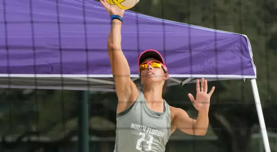 UNF volleyball player serves the ball
