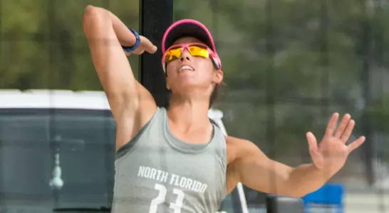 UNF volleyball player serves the ball