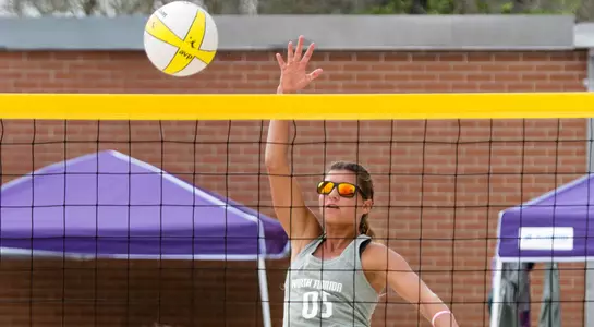UNF beach volleyball player up at the net for the hit