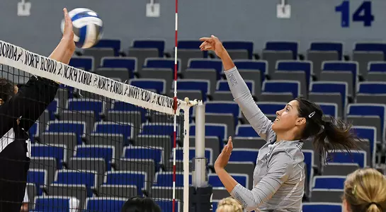 UNF volleyball player spikes the ball