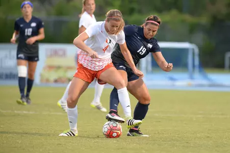 UNF women's soccer player fights for possession against opponent