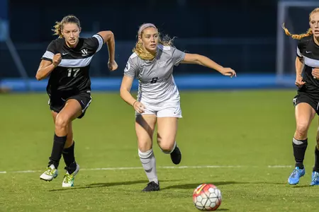 UNF women's soccer player dribbles up the field
