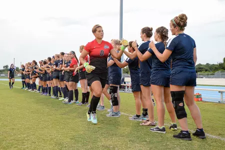 UNF women's soccer team high-five teammate