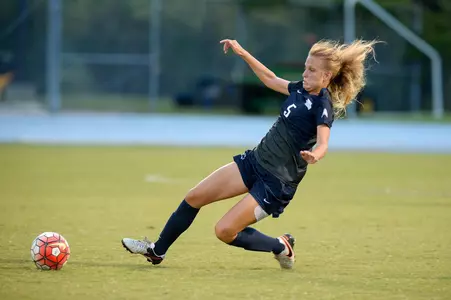 UNF women's soccer player makes a slide tackle