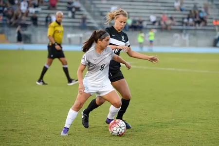 UNF women's soccer player defends the ball against an opponent