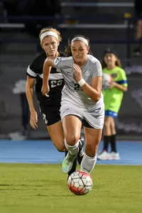UNF women's soccer player dribbles up the field