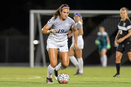 UNF women's soccer player dribbles up the field