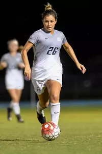 UNF women's soccer player dribble the ball up the field