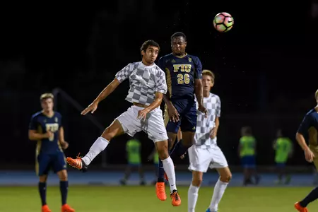 UNF men's soccer players compete for header with an opponent