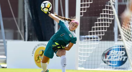 Rhiannon Conelley throws soccer ball away from net.