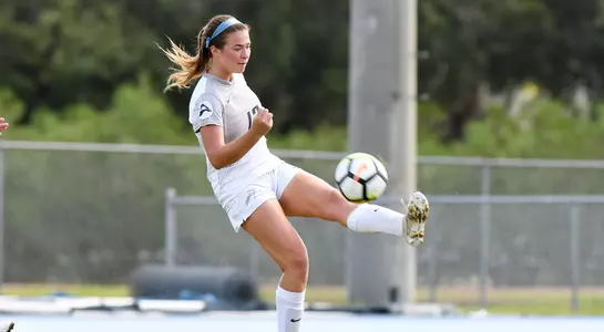Haley Cook kicks the ball in the air.
