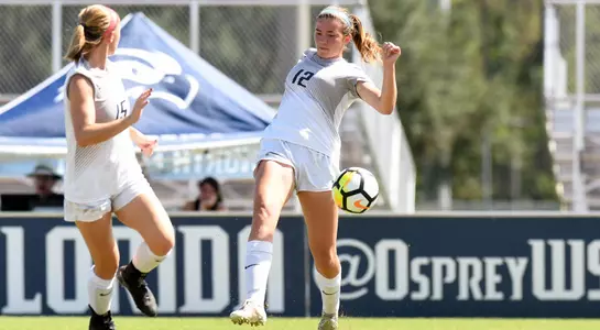 Haley Cook kicks the soccer ball to her teammate.