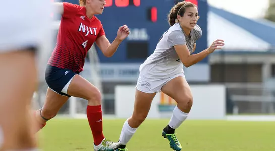 Sara DeLucca is running towards the soccer ball.