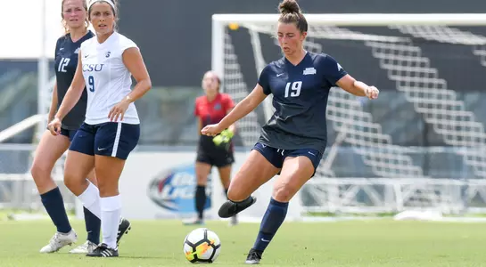 Amber Jones kicks the ball away from opponent.