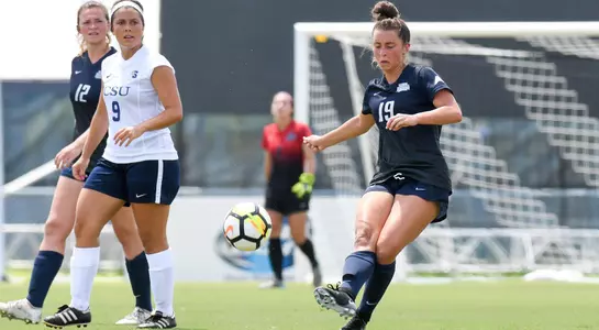 Amber Jones kicks the soccer ball away from the opponent.