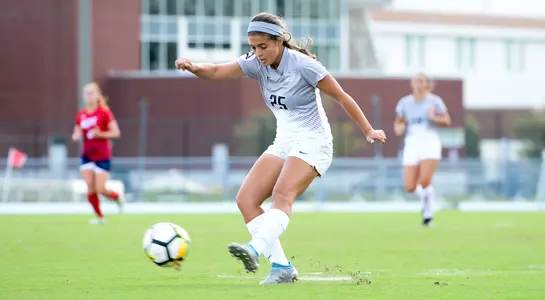 Madi Sagas kicks the soccer ball.
