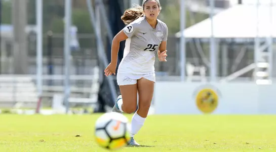 Madi Sagas kicks the soccer ball.