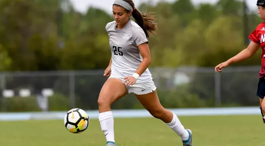 Madi Sagas kicks the soccer ball.
