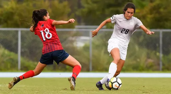 Andrea Sanchez is keeping the ball away from her opponent.