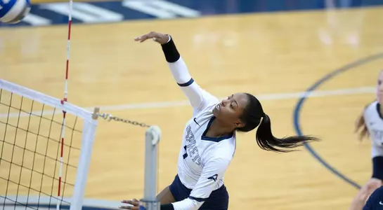 Devyn Wheeler goes against the net to attack the volleyball.