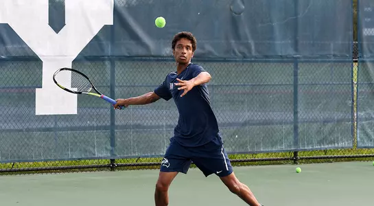 Deshmukh returns a ball over the net.