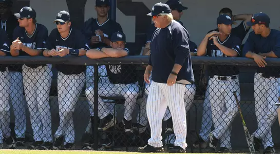 Head coach Smoke Laval stands in front of the Osprey dugout during a game