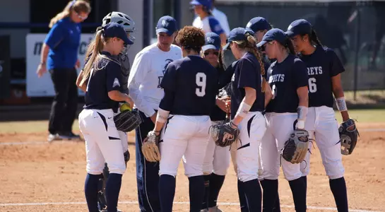 Softball huddles at the pitching circle