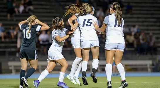 Several UNF players celebrate Alexis Bredeau's goal
