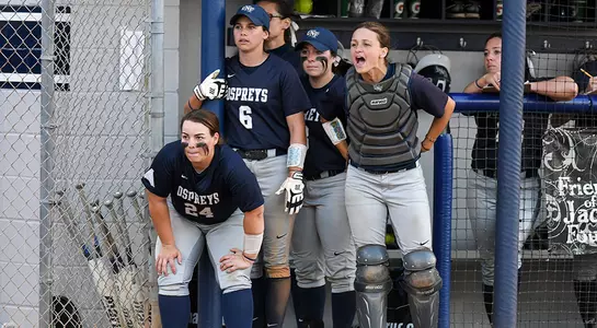 The softball team cheers from the dugout