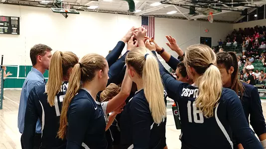 The volleyball team huddles before a game