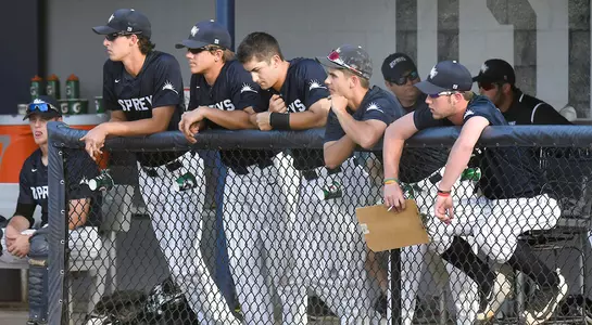 Several UNF players watch the game from the dugout