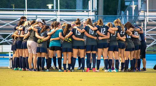 Women's soccer huddles before a match.
