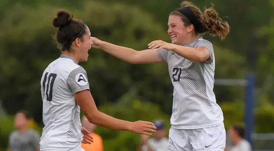 Thais Reiss and Kendra Hoffman give each other a hug to celebrate a goal