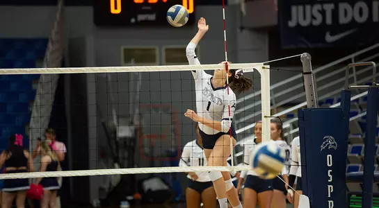 Solimar Cestero jumps up to connect with the volleyball at the net.