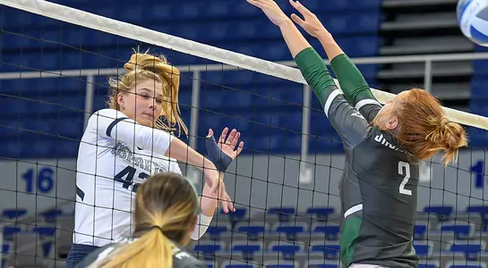 Taryn Griffey hits the ball past a blocker during the volleyball match.