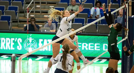 Taryn Griffey reaches out to connect with the volleyball near the net.